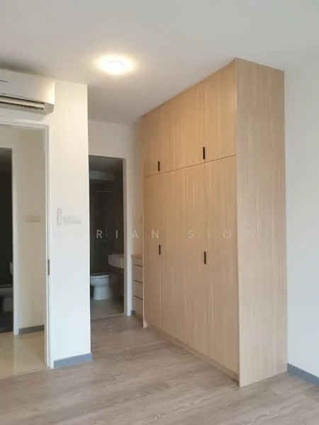 Bedroom features: light wood cabinetry, built-in wardrobe with sliding doors, laminate flooring, ceiling light fixture, wall-mounted split AC, neutral wall color, doorway leading to bathroom, visible bathroom door; style: modern.