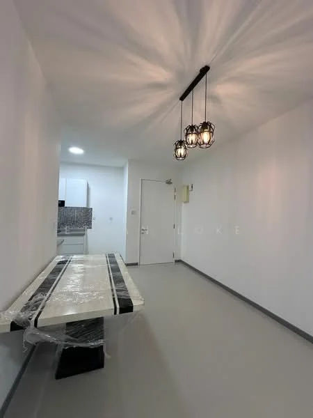 Dining features: white painted walls, grey flooring, 3-bulb pendant light fixture, dining table with plastic wrap, open layout, door to hallway, kitchen visible in background; style: modern.