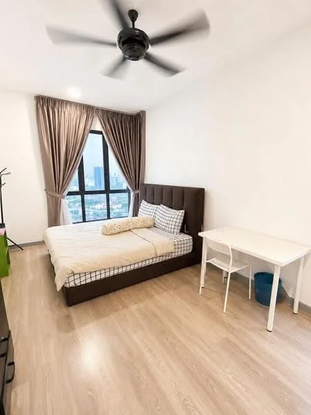Bedroom features: king-size bed with upholstered headboard, white bedding with checkered pattern, floor-to-ceiling windows, grey curtains, light wood flooring, ceiling fan with light, study desk with white finish, plastic waste bin, decorative pillow, wall-mounted coat rack; style: modern; view: city.