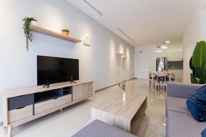 Living features: light grey painted walls, polished tile flooring, sofa in light grey fabric, wooden coffee table, TV console in light wood, wall-mounted flat-screen TV, shelf with decorative plants, pendant lighting, dining area visible in background, open layout, large windows with natural light; style: modern.