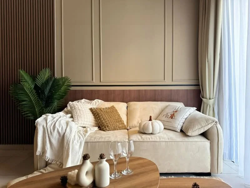 Living features: cream fabric sofa, decorative throw pillows, white throw blanket, wooden coffee table, glassware on table, decorative pumpkin, potted plant, textured wall paneling, curtains, neutral wall color, light-colored flooring; style: modern.