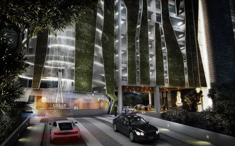 Exterior type: high-rise condominium; features: glass curtain wall, green vertical gardens, water feature at entrance, double-volume main lobby, porte cochère drop-off, manicured landscaping, surrounded by mature greenery, driveway with interlocking pavers; style: modern.