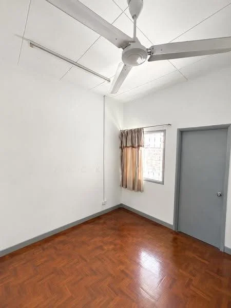 Room features: white painted walls, wooden flooring, 5-blade ceiling fan, window with sheer curtains, grey door, corner window, light-colored ceiling, baseboard trim.