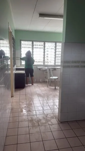Laundry features: green painted walls, white tiled flooring, window with horizontal slats, sink, washing machine, plastic chair, countertop, light fixture.
