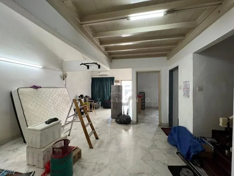 Room features: white painted walls, marble tile flooring, exposed wooden beams on ceiling, large window with green curtains, mattress leaning against wall, ladder, refrigerator, various furniture items, cluttered space.