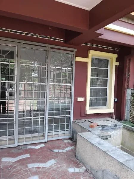 Exterior features: metal security grille doors, sliding glass doors, red painted facade, cream window frames, concrete platform, brick pavers, surrounding greenery; style: traditional.