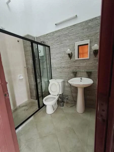 Bathroom features: walk-in shower with glass enclosure, chrome handheld shower, white toilet, white pedestal sink, wall-mounted mirror, wall sconces, grey stone wall tiles, beige floor tiles; style: modern.