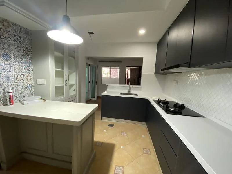 Kitchen features: black cabinetry, white quartz countertop, single-bowl stainless-steel sink, chrome pull-down faucet, built-in gas hob, white tiled backsplash with herringbone pattern, decorative patterned tiles on one wall, pendant light fixture, open shelving, floor tiles with geometric pattern; style: modern. Room features: doorway leading to another room, window with natural light.