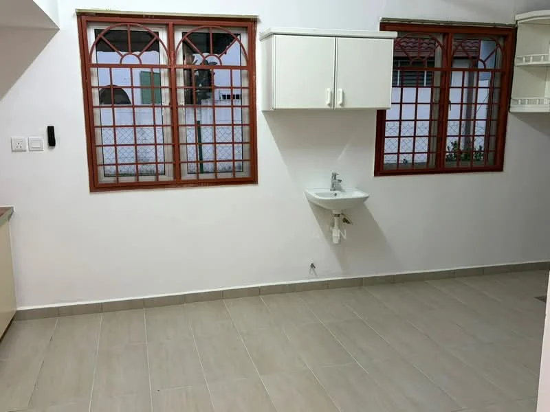 Room features: white painted walls, grey tiled flooring, two red-framed windows, wall-mounted sink, cabinets above the sink, open space layout.