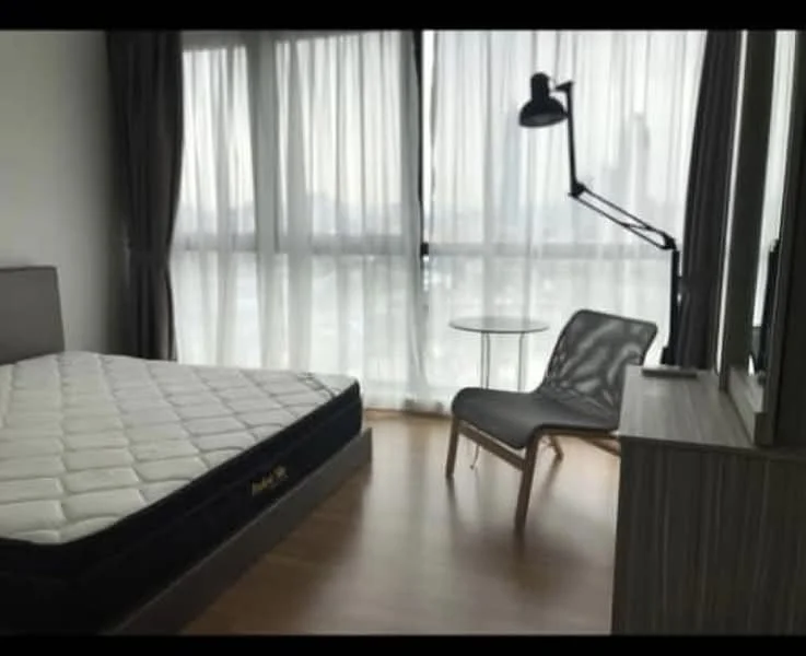 Bedroom features: queen-size bed, floor-to-ceiling windows, sheer curtains, wooden flooring, reading lamp, side table, chair, built-in wardrobe; style: modern; view: city.