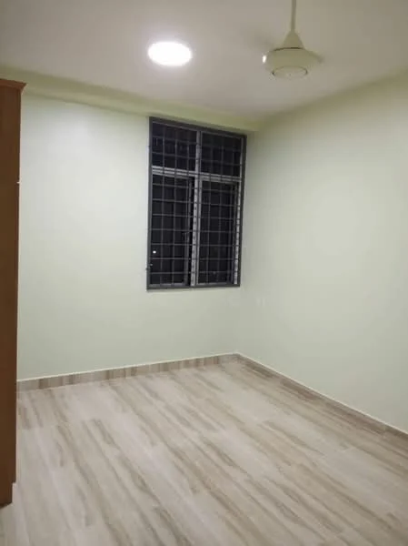 Room features: light green painted walls, laminate flooring, ceiling fan, window with security grille, neutral-colored baseboards, single light fixture, corner wardrobe, no visible furniture; style: modern.