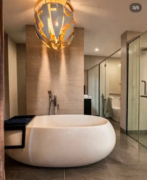 Bathroom features: freestanding bathtub, chrome floor-mounted tub filler, glass shower enclosure, wall-mounted toilet, tile cladding on walls, grey tile flooring, modern pendant light fixture, recessed lighting, large mirror, vanity with storage; style: modern.