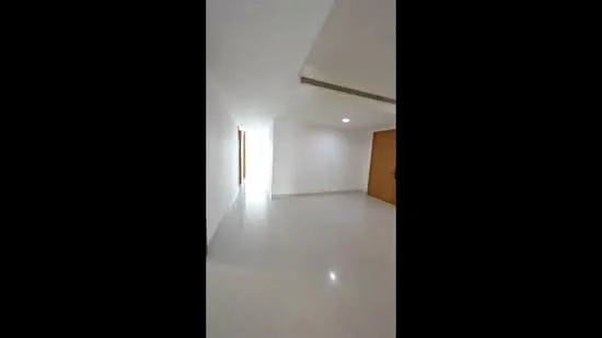 Room features: white painted walls, polished tile flooring, recessed downlights, natural light from windows, wooden door, open layout; style: modern.