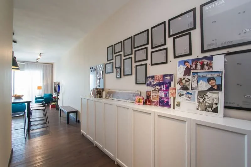 Room features: wood flooring, white painted walls, framed artwork, photo collage, console table, bar stools, recessed lighting, large windows, decorative mirrors; style: modern.