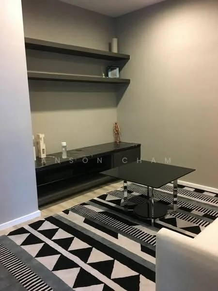 Living features: grey painted walls, wooden flooring, black coffee table with chrome legs, black console table, open shelving unit, decorative vases, area rug with geometric pattern, wall-mounted decor; style: modern.