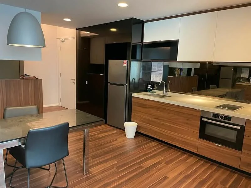 Kitchen features: stainless-steel fridge, built-in oven, 4-burner gas hob, single-bowl stainless-steel sink, chrome pull-down faucet, white cabinetry, wooden cabinetry, grey countertop, mirrored backsplash, pendant light, dining table with glass top, black dining chairs, wooden flooring, recessed downlights; style: modern.