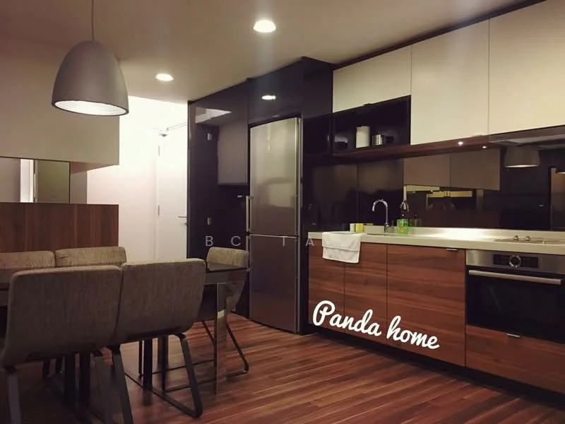 Kitchen features: stainless-steel fridge, built-in oven, 4-burner gas hob, single-bowl stainless-steel sink, chrome pull-down faucet, dark wood cabinetry, white upper cabinets, marble countertop, pendant light, wooden flooring, dining table with grey upholstered chairs; style: modern.