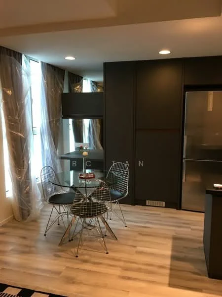 Dining features: round glass dining table, 4 wire-frame dining chairs, wooden flooring, large windows with sheer curtains, recessed LED downlights, black cabinetry, stainless-steel fridge, open layout to kitchen area; style: modern.
