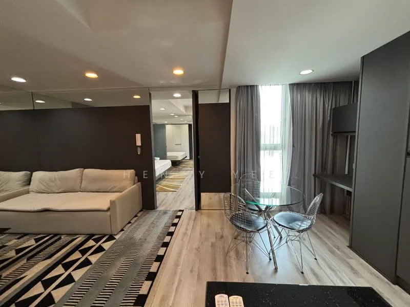 Living features: 3-seater fabric sofa in white, area rug with geometric pattern, glass dining table with metal chairs, wooden flooring, floor-to-ceiling windows, curtains, recessed downlights, wall-mounted TV, mirrored wall, decorative wall paneling; style: modern. Room features: bedroom area visible in background, light-colored walls, grey curtains.
