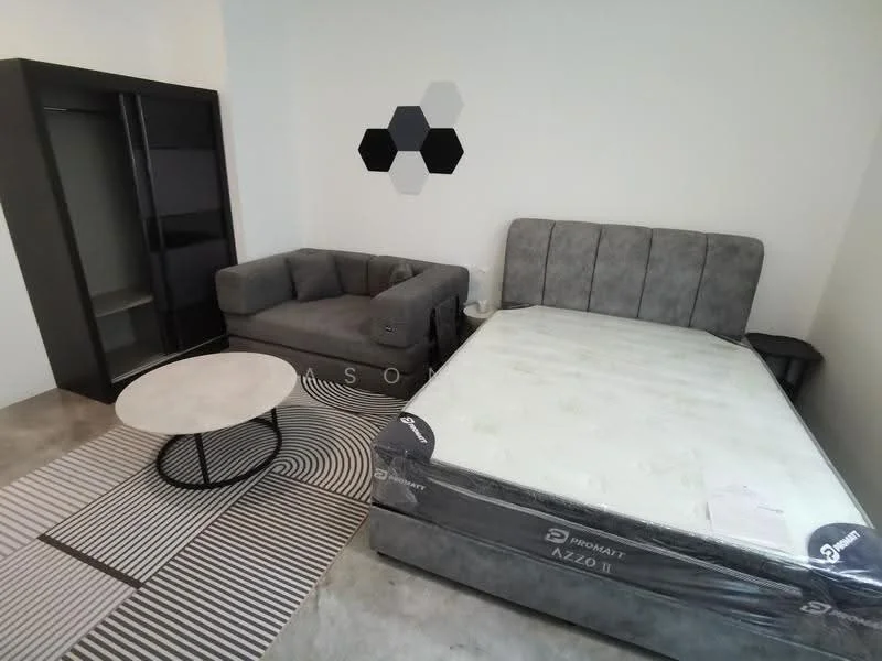 Bedroom features: queen-size bed with grey upholstered headboard, mattress on bed frame, grey fabric sofa, round coffee table with white top, black shelving unit, geometric wall decor with hexagonal shapes, area rug with striped pattern, concrete flooring, white painted walls, light source not visible; style: modern.
