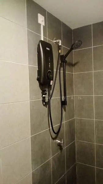 Bathroom features: black electric shower unit, handheld shower head, wall-mounted shower hose, grey ceramic tile walls, grey ceramic tile flooring, chrome faucet, water supply pipe, shower wall with no enclosure; style: modern.