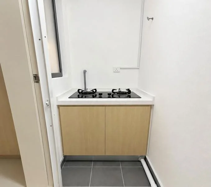 Kitchen features: gas hob with two burners, white countertop, light wood cabinetry, grey tile flooring, white painted walls, single window, wall-mounted faucet, kitchen sink plumbing visible; style: modern.