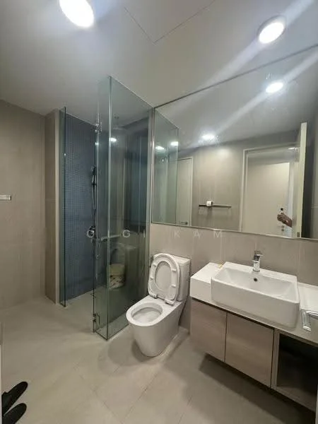 Bathroom features: glass shower enclosure, rain shower head, handheld shower, single-sink vanity with wood cabinet, white ceramic sink, chrome basin mixer, one-piece toilet, mirror above vanity, lighted ceiling, grey tiled walls, light grey floor tiles; style: modern.