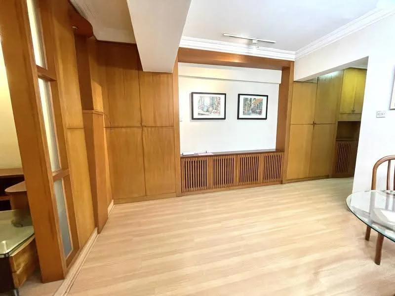 Living features: wood paneling on walls, light wood cabinetry, glass panel doors, laminate flooring, recessed lighting, two framed artworks on wall, built-in storage unit, open layout, neutral wall color, crown moulding; style: modern.