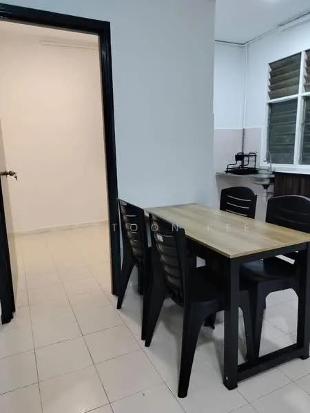Dining features: rectangular wooden dining table, 4 black plastic dining chairs, white tiled flooring, plain white walls, black door frame, window with horizontal slats, kitchen area visible in background, light source from ceiling; style: modern. Room features: plain white walls, white tiled flooring, door leading to another room.