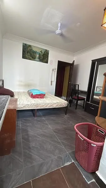 Bedroom features: queen-size bed, mattress with beige cover, red and blue blankets, wooden wardrobe with mirror, black chair, ceiling fan, dark tiled flooring, wall-mounted artwork, laundry basket, wooden dresser.