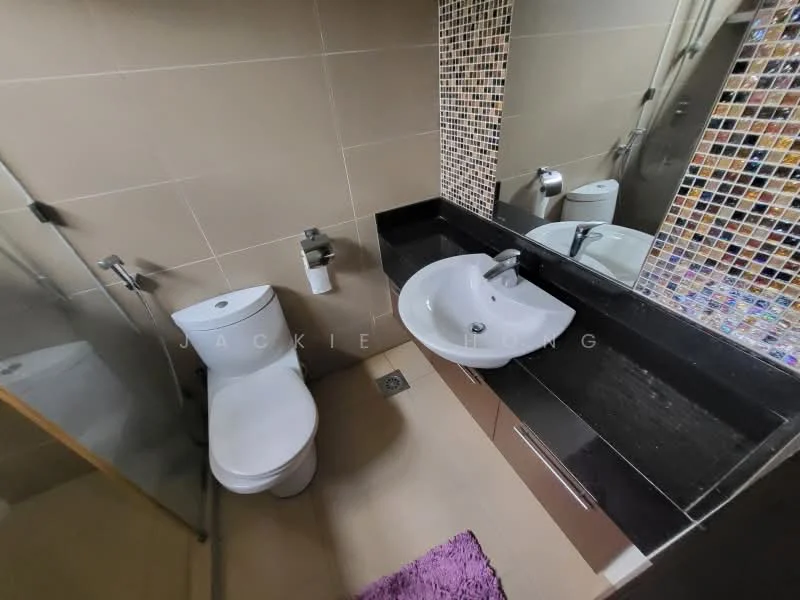 Bathroom features: one-piece toilet, single-sink vanity with black countertop, round basin, chrome basin mixer faucet, mirror with mosaic tile border, glass shower enclosure, tile flooring, beige wall tiles, purple bath mat; style: modern.