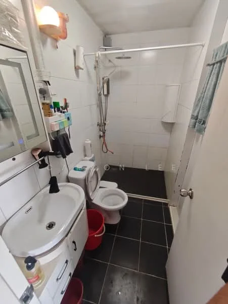 Bathroom features: white tiled walls, black ceramic tile flooring, single-sink vanity with cabinet, chrome basin mixer faucet, framed mirror above sink, toilet, walk-in shower with glass enclosure, handheld shower, shower head, towel rack, shower curtain rod, plastic storage containers; style: modern.