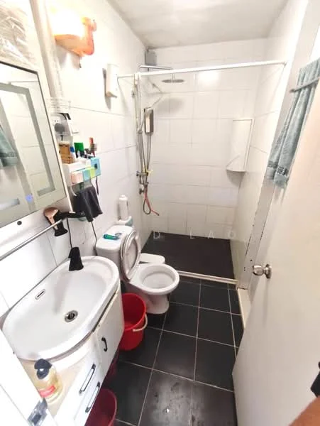 Bathroom features: white tiled walls, black ceramic tile flooring, single-sink vanity with cabinet, chrome basin mixer faucet, framed mirror above sink, one-piece toilet, walk-in shower with glass enclosure, rain shower head, shower wall with white tiles, toilet paper holder, shower caddy, two red plastic buckets; style: modern.