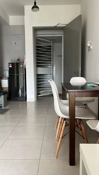 Dining features: dining table with wooden legs, 4 white plastic dining chairs, grey tiled flooring, white walls, pendant light fixture, open doorway leading to hallway, black fridge, kitchen area visible in background; style: modern. Room features: grey door, metal railing, bathroom door visible, white wall with no decor.