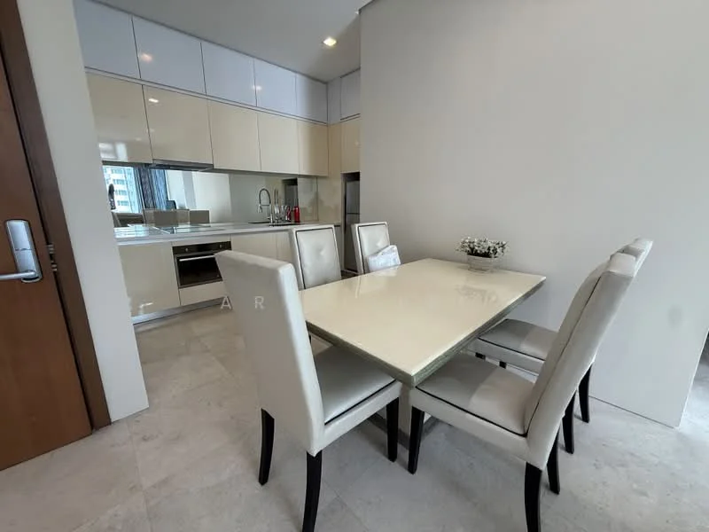 Dining features: glass dining table, 4 upholstered dining chairs in cream, white cabinetry, stainless-steel appliances visible in kitchen, marble flooring, recessed downlights, open-plan layout to kitchen, neutral wall colour; style: modern. Kitchen features: white cabinetry, stainless-steel sink, built-in oven, built-in refrigerator, countertop with glossy finish, tile backsplash, recessed downlights; style: modern.