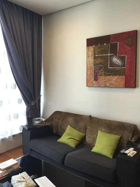 Living features: grey fabric sofa, two green accent cushions, wooden coffee table, framed artwork on wall, floor-to-ceiling window with sheer curtains, dark curtain drapes, wooden flooring, decorative items on coffee table; style: modern.