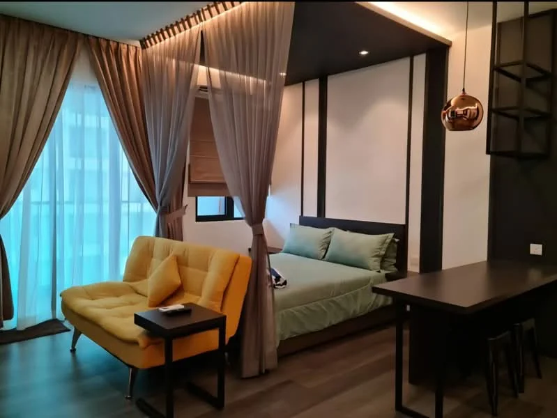 Bedroom features: queen-size bed with green bedding, yellow fabric sofa, black side table, wooden flooring, floor-to-ceiling windows with sheer curtains, recessed ceiling lights, wall-mounted shelf, decorative wall paneling; style: modern.