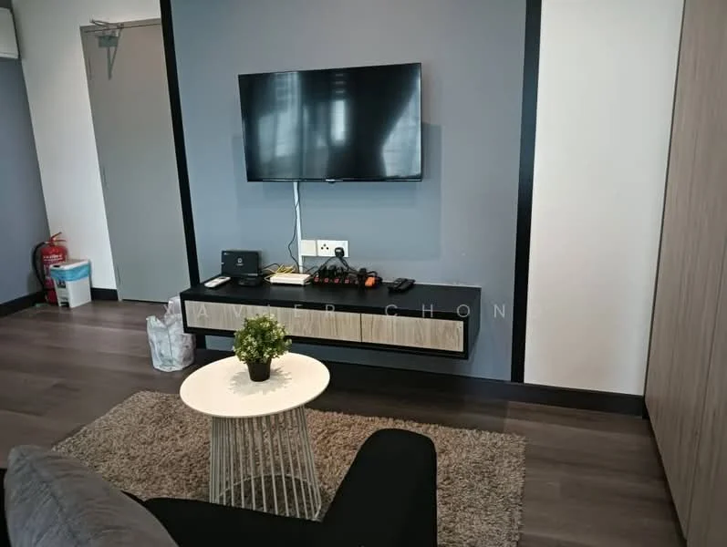Living features: grey painted walls, dark wood flooring, wall-mounted TV, black media console, white round coffee table, grey fabric sofa, decorative plant on table, area rug with neutral color, fire extinguisher visible, trash bin visible; style: modern.