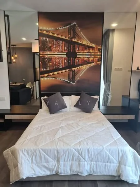 Bedroom features: queen-size bed with white bedding, decorative pillows with letters, wall-mounted artwork with city skyline, wooden flooring, built-in bedside shelf, recessed lighting, curtains, mirror panel on wall, neutral wall color; style: modern; view: city.
