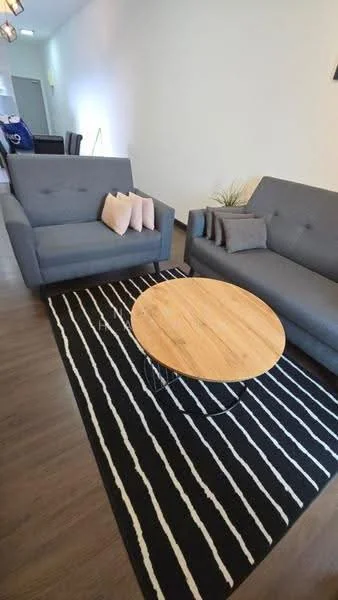 Living features: 2-seater fabric sofa in grey, 3-seater fabric sofa in grey, round wooden coffee table, area rug with black and white stripes, decorative cushions in pink, plant in ceramic pot, laminate flooring, white painted walls; style: modern.