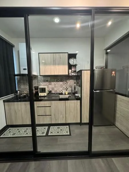Kitchen features: black granite countertop, wood cabinetry with light finish, black and white patterned backsplash, stainless-steel fridge, microwave, built-in oven, single-bowl stainless-steel sink, chrome pull-down faucet, recessed downlights, floor-to-ceiling windows, grey laminate flooring, decorative rug; style: modern.