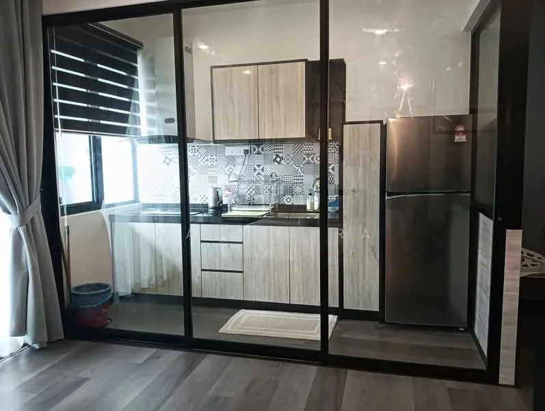 Kitchen features: black granite countertop, wood cabinetry with light finish, stainless-steel fridge, built-in oven, 4-burner gas hob, mosaic tile backsplash, single-bowl stainless-steel sink, window with black blinds, grey vinyl plank flooring, recessed downlights; style: modern.