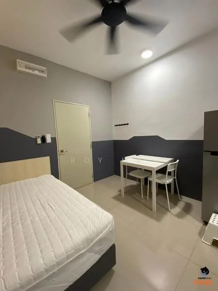 Bedroom features: queen-size bed, white bedding, light grey painted walls, dark grey accent wall, ceiling fan, wall-mounted air conditioning unit, small dining table, two white chairs, fridge, tile flooring, built-in wardrobe, light fixture; style: modern.