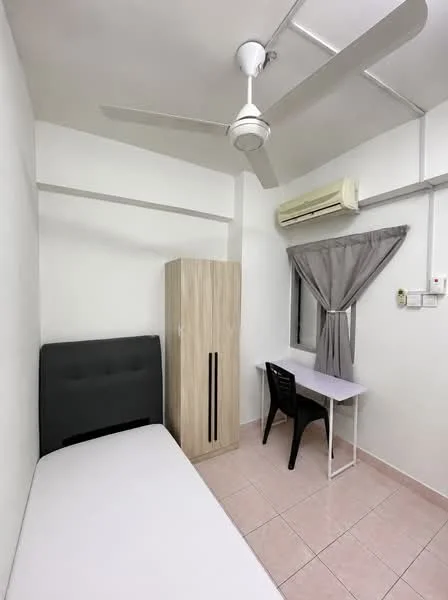 Bedroom features: single bed with grey upholstered headboard, light wood wardrobe with sliding doors, study desk with white surface, black plastic chair, floor-to-ceiling window with grey curtains, wall-mounted split AC unit, 5-blade ceiling fan with light, pink ceramic tile flooring, white painted walls; style: modern.