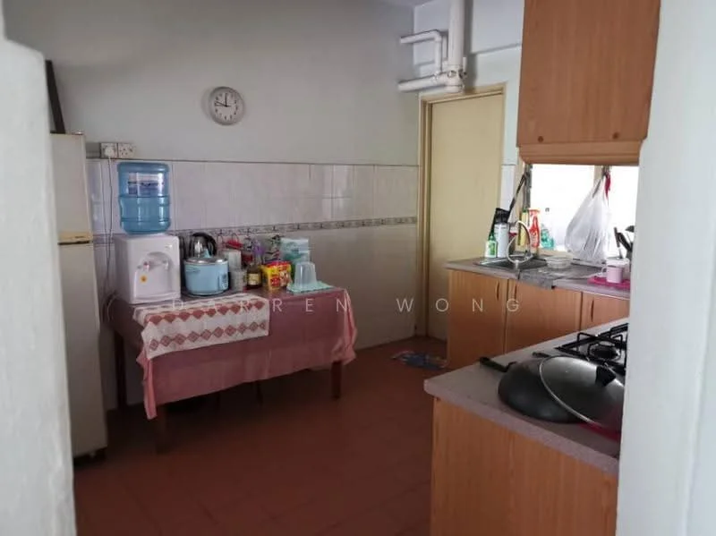 Kitchen features: light brown wooden cabinetry, grey countertop, stainless-steel gas hob, single-bowl stainless-steel sink, chrome pull-down faucet, white tiled backsplash, water dispenser, microwave, kettle, various food containers, pink tablecloth, clock on wall, brown tiled flooring.