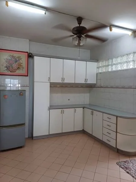 Kitchen features: white cabinetry with silver handles, grey countertop, built-in cabinets, fridge, ceiling fan with 4 blades, white tiled walls, pink tiled flooring, glass block window, framed floral artwork on wall.
