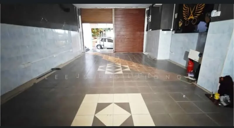 Room features: grey tiled flooring, white tiled walls, decorative floor tiles with geometric pattern, roller shutter door, exposed electrical outlets, fire extinguisher, wall-mounted fixtures, large open space.