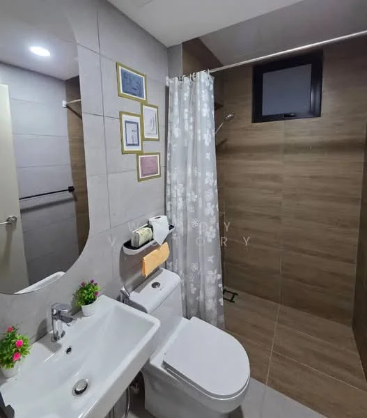 Bathroom features: white ceramic sink, chrome basin mixer faucet, one-piece toilet, walk-in shower with glass enclosure, rain shower head, tiled walls with grey and brown tones, white shower curtain with floral pattern, small potted plants on sink, wall-mounted towel rack, mirror above sink, recessed lighting; style: modern.