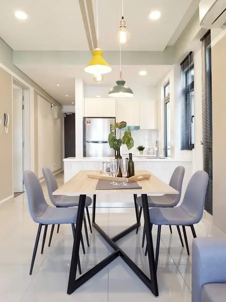 Dining features: 6-seater dining table, light wood tabletop, black metal legs, upholstered dining chairs in light grey, pendant lighting with yellow and green shades, white walls, recessed ceiling lights, large windows with black blinds, air conditioning unit on wall, open layout to kitchen, decorative plant on table; style: modern. Room features: white cabinetry, stainless-steel fridge, countertop with sink, tile flooring.