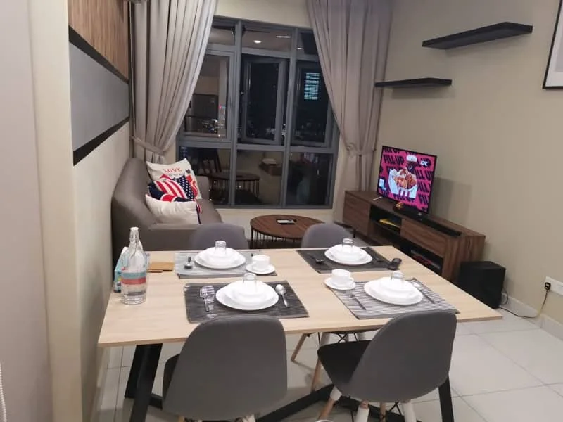 Dining features: dining table with 4 grey chairs, white dinner plates, grey placemats, water bottle on table, wall-mounted TV, wooden TV console, light grey sofa, decorative cushions, floor-to-ceiling windows with sheer curtains, shelves on wall, neutral wall colour, tile flooring; style: modern; view: city.